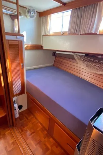  Yacht Photos Pics Cozy cabin interior of 1990 Grand Banks 36 Europa with wooden accents and comfortable bedding.