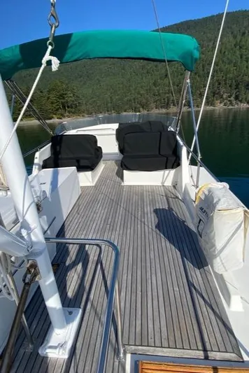  Yacht Photos Pics 1990 Grand Banks 36 Europa yacht deck with seating, green canopy, scenic water view.