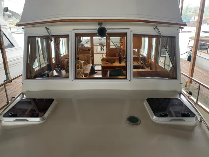  Yacht Photos Pics 1990 Grand Banks 36 Europa yacht interior view with wooden furnishings and large windows.