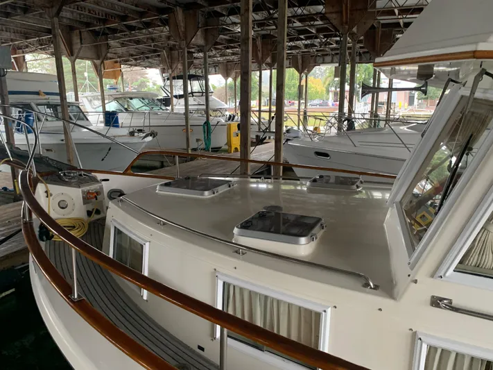  Yacht Photos Pics 1990 Grand Banks 36 Europa yacht docked in a marina under a covered shelter.