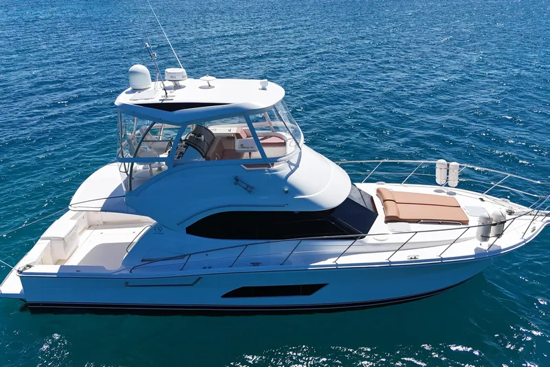  Yacht Photos Pics 2012 Riviera 43 Flybridge yacht on clear blue water, showcasing sleek design and spacious deck.