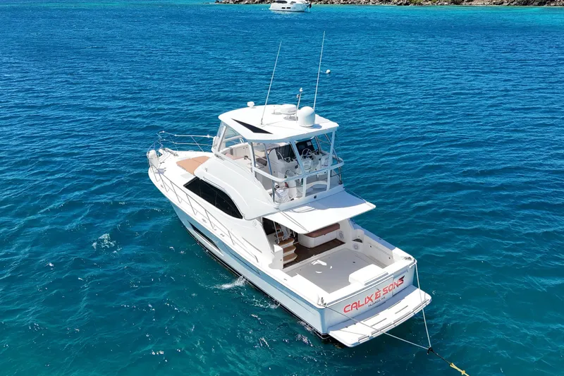  Yacht Photos Pics 2012 Riviera 43 Flybridge yacht anchored in clear blue ocean waters.