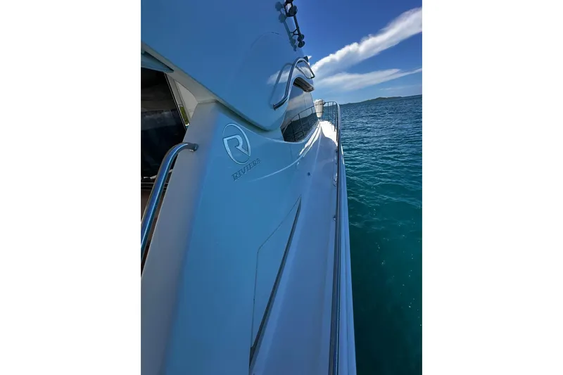  Yacht Photos Pics Riviera 43 Flybridge yacht, 2012 model, cruising on clear blue waters under a sunny sky.