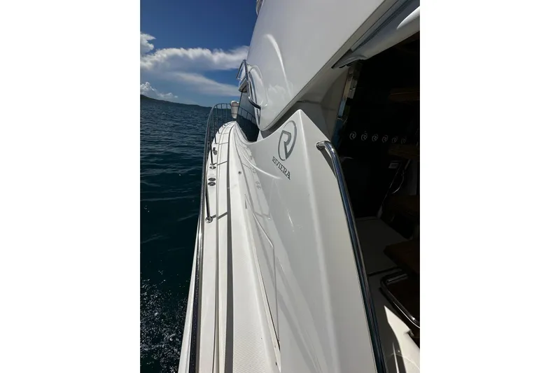  Yacht Photos Pics 2012 Riviera 43 Flybridge yacht on open water, showcasing sleek design and luxury features.