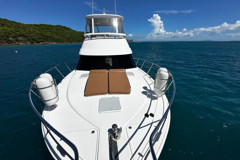  Yacht Photos Pics 2012 Riviera 43 Flybridge yacht on calm blue waters, featuring spacious deck and scenic backdrop.