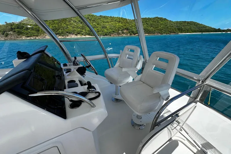 Yacht Photos Pics Flybridge of 2012 Riviera 43, featuring dual white captain chairs, overlooking serene blue waters.