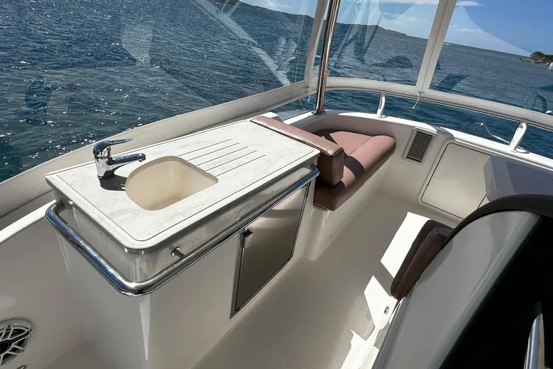  Yacht Photos Pics Flybridge interior of 2012 Riviera 43, featuring a sink and seating with ocean view.