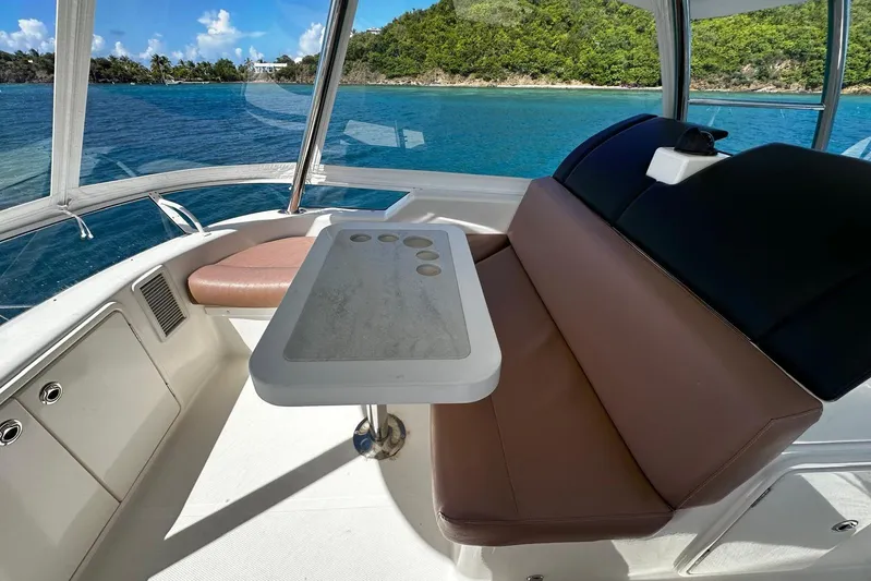  Yacht Photos Pics Interior of 2012 Riviera 43 Flybridge yacht with seating and table, overlooking blue waters.