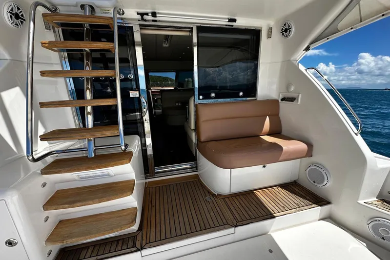  Yacht Photos Pics Luxurious 2012 Riviera 43 Flybridge yacht interior with wooden steps and cushioned seating.