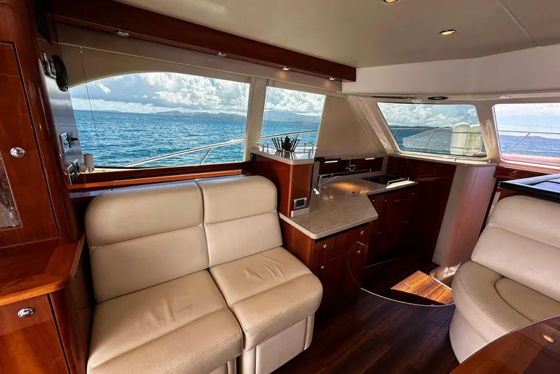 Yacht Photos Pics Luxurious interior of 2012 Riviera 43 Flybridge yacht with ocean view through large windows.