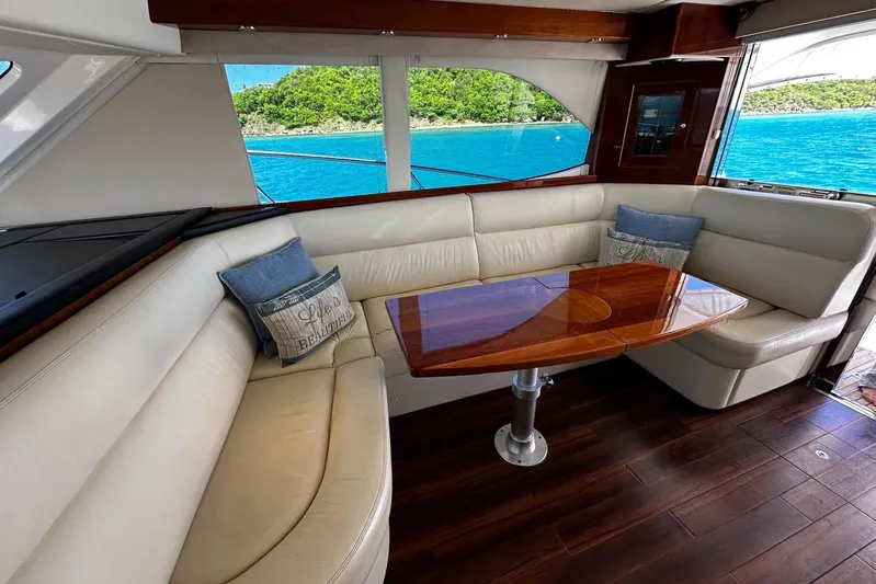  Yacht Photos Pics Luxurious interior of 2012 Riviera 43 Flybridge yacht with elegant seating and wooden table.