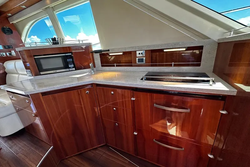  Yacht Photos Pics Luxurious kitchen interior of 2012 Riviera 43 Flybridge yacht with modern appliances and wood finish.