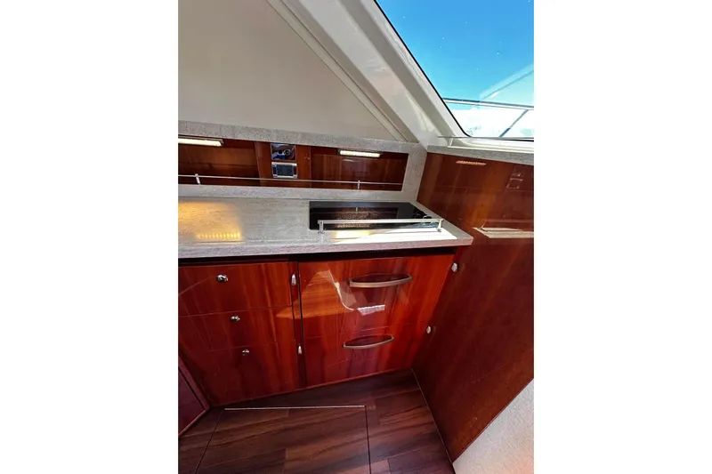  Yacht Photos Pics Luxurious interior of 2012 Riviera 43 Flybridge yacht with sleek wood cabinetry and modern fixtures.