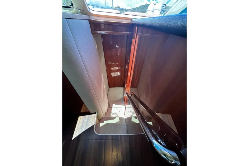  Yacht Photos Pics Interior stairs of 2012 Riviera 43 Flybridge yacht with wooden finish and handrail.
