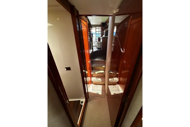  Yacht Photos Pics Interior hallway of 2012 Riviera 43 Flybridge yacht with wooden finishes and carpeted flooring.