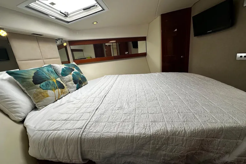  Yacht Photos Pics Luxurious bedroom interior of 2012 Riviera 43 Flybridge yacht with skylight and floral pillows.