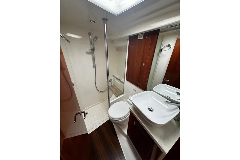  Yacht Photos Pics Bathroom interior of 2012 Riviera 43 Flybridge yacht, featuring shower, sink, and toilet.