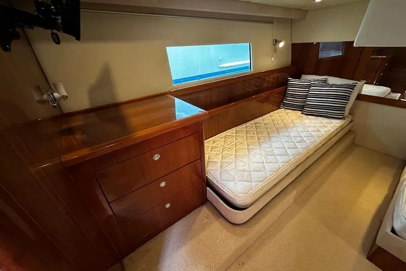  Yacht Photos Pics Luxurious cabin interior of 2012 Riviera 43 Flybridge yacht with single bed and wooden cabinetry.