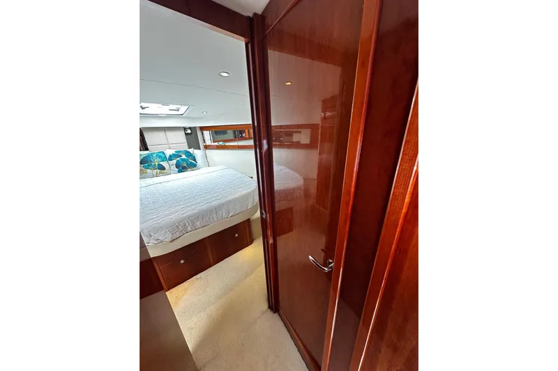  Yacht Photos Pics Luxurious bedroom interior of 2012 Riviera 43 Flybridge yacht with wooden finishes.