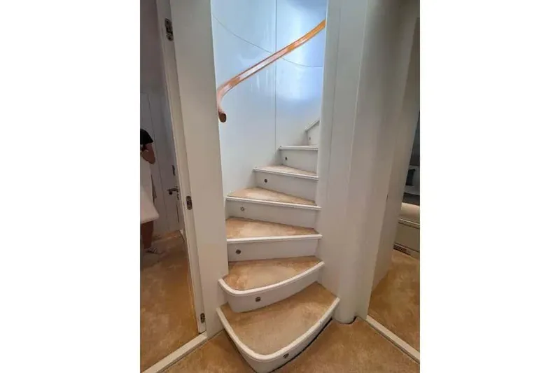  Yacht Photos Pics Curved staircase inside 2000 Sanlorenzo SL88 yacht with beige carpet and sleek design.