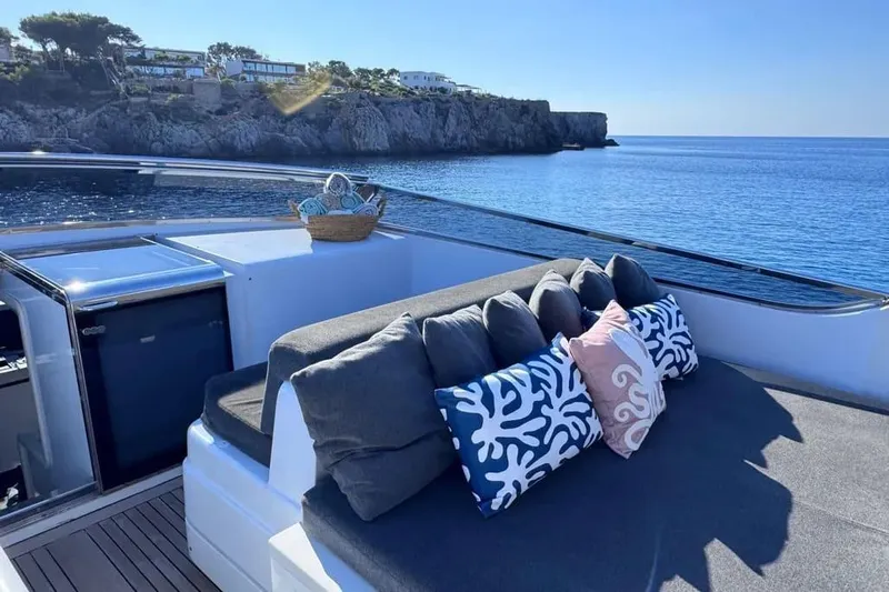  Yacht Photos Pics Luxurious Sanlorenzo SL88 yacht deck with cushions, overlooking serene coastal waters.