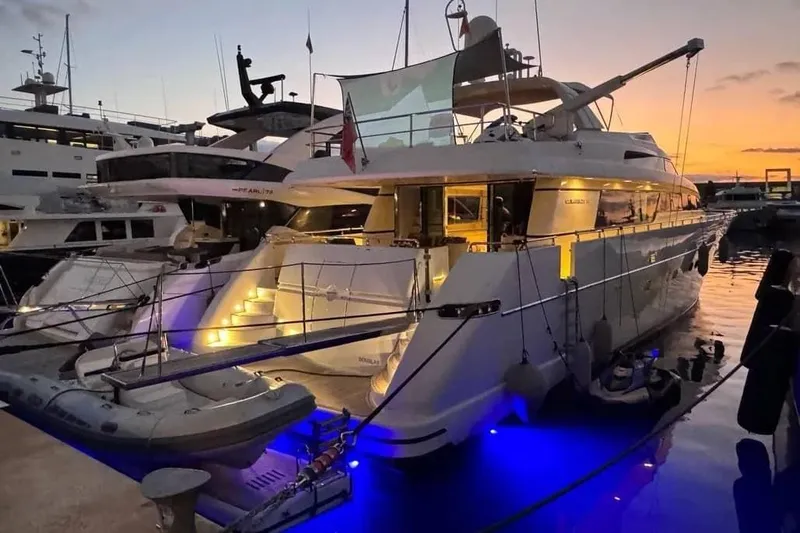  Yacht Photos Pics Luxurious 2000 Sanlorenzo SL88 yacht docked at sunset, illuminated with blue lights.
