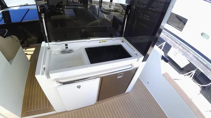  Yacht Photos Pics Outdoor kitchenette on 2024 De Antonio Yachts D50, featuring sink and cooktop.