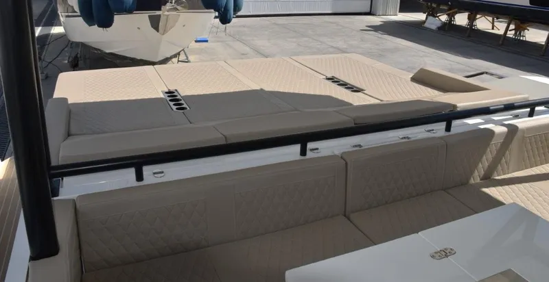  Yacht Photos Pics 2024 De Antonio Yachts D50 with beige seating and sunbathing area, docked outdoors.