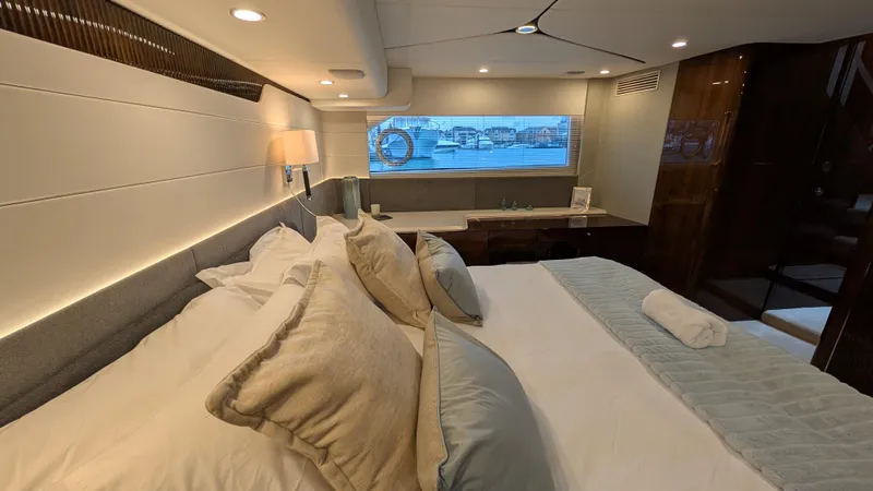 New 2025 Model Yacht Photos Pics Luxurious bedroom interior of 2025 Fairline Squadron 58 yacht with elegant bedding and window view.