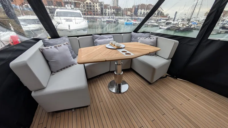 New 2025 Model Yacht Photos Pics Luxurious seating area on 2025 Fairline Squadron 58 yacht, featuring elegant table and cushions.