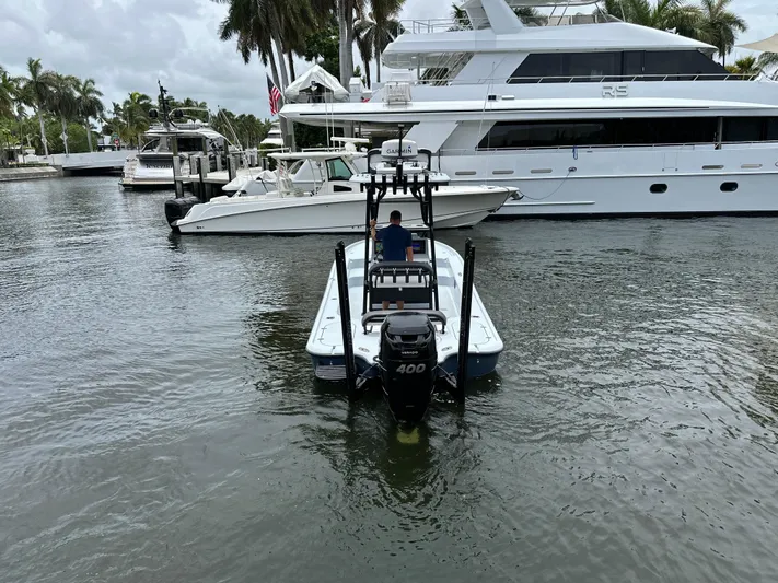  Yacht Photos Pics 2019 Yellowfin 24 Bay CE boat navigating marina near luxury yachts.
