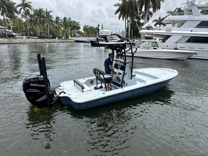  Yacht Photos Pics 2019 Yellowfin 24 Bay CE boat on water, with palm trees and yachts in the background.