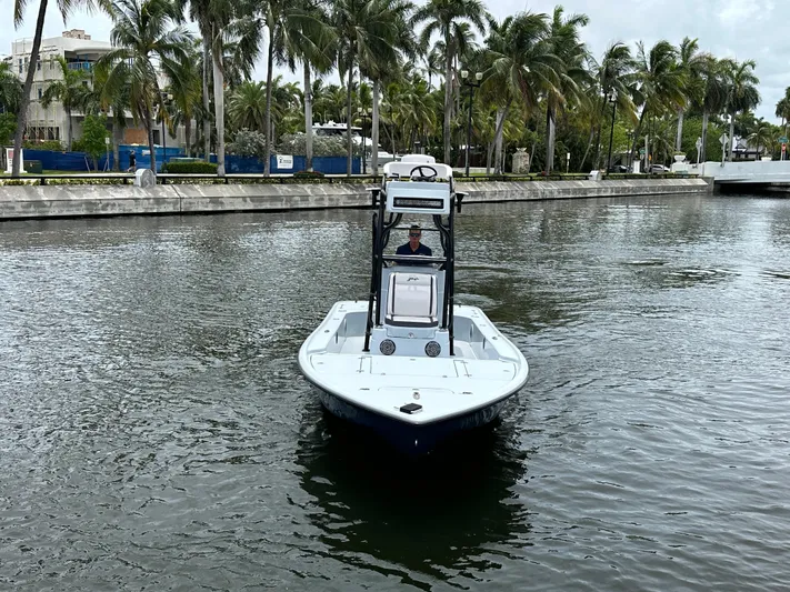  Yacht Photos Pics 2019 Yellowfin 24 Bay CE boat cruising on a palm-lined waterway.