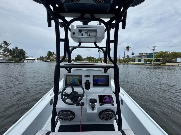 Yacht Photos Pics 2019 Yellowfin 24 Bay CE boat dashboard with navigation screens on a calm waterway.