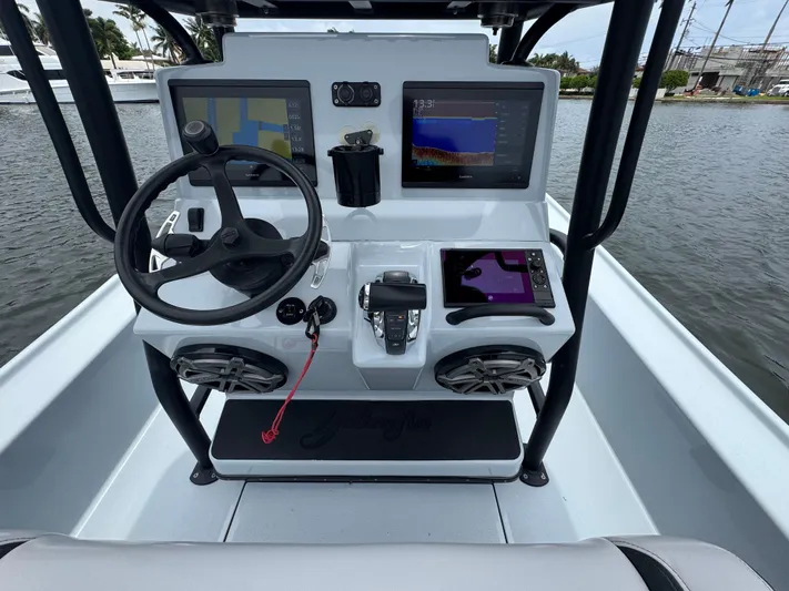  Yacht Photos Pics 2019 Yellowfin 24 Bay CE boat dashboard with steering wheel and navigation screens.