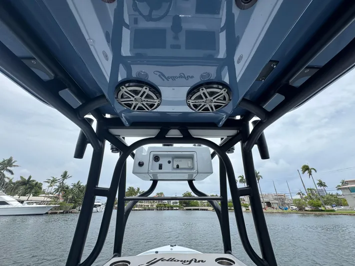  Yacht Photos Pics 2019 Yellowfin 24 Bay CE boat with speakers and console, docked near palm trees.