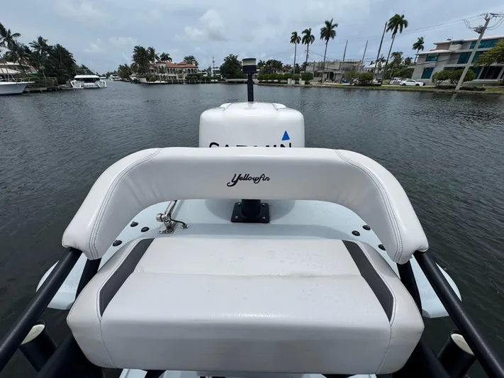  Yacht Photos Pics 2019 Yellowfin 24 Bay CE boat on a calm waterway, surrounded by palm trees.