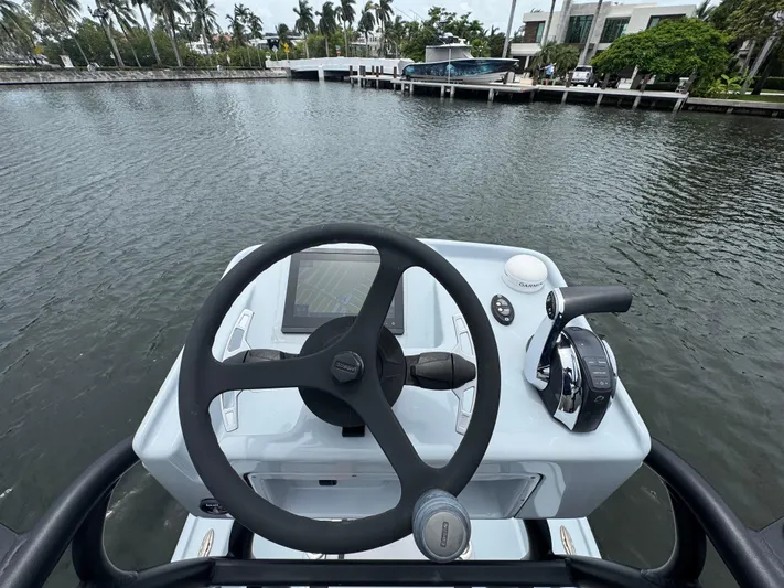  Yacht Photos Pics 2019 Yellowfin 24 Bay CE boat helm with steering wheel and controls on water.