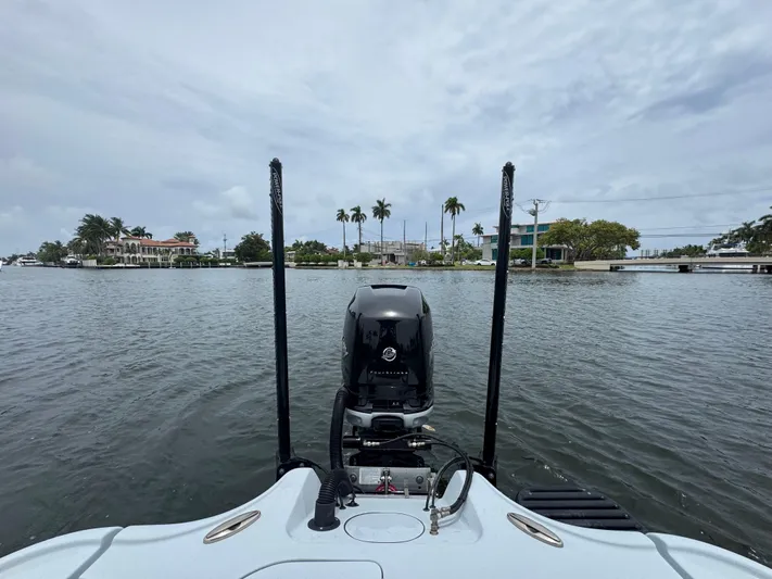  Yacht Photos Pics 2019 Yellowfin 24 Bay CE boat on water, scenic waterfront view with palm trees.