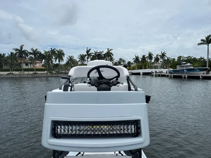  Yacht Photos Pics 2019 Yellowfin 24 Bay CE boat docked near palm trees and waterfront homes.