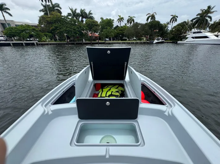  Yacht Photos Pics 2019 Yellowfin 24 Bay CE boat with open storage compartments on a calm waterway.