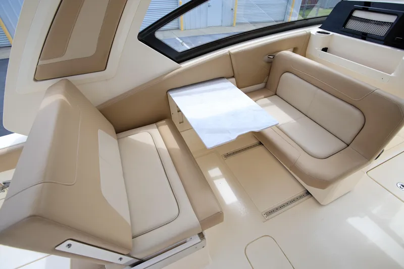 Yacht Photos Pics 2022 Scout 277 Dorado boat interior with beige seating and a central table.