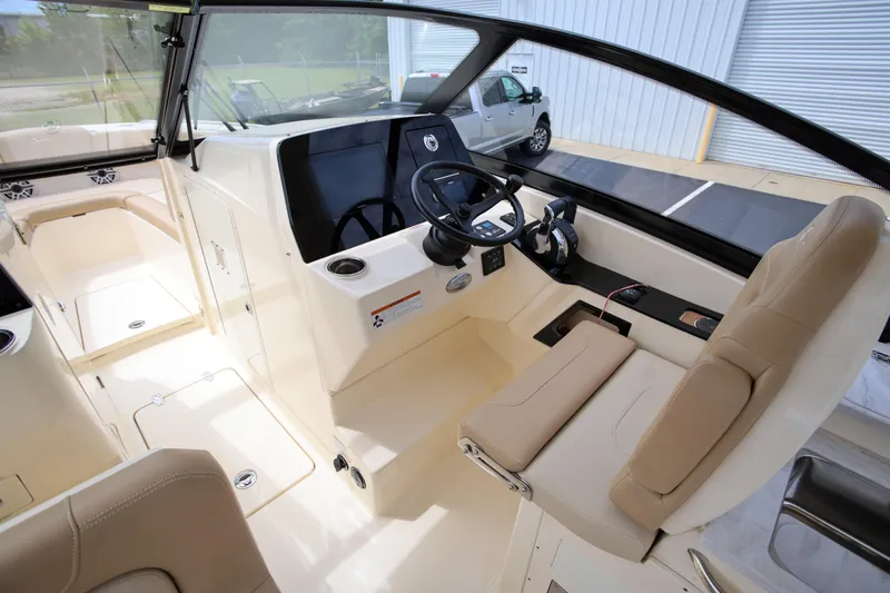  Yacht Photos Pics 2022 Scout 277 Dorado boat interior with steering wheel and seating area.