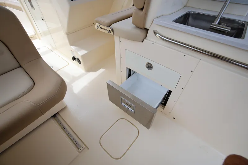 Yacht Photos Pics 2022 Scout 277 Dorado boat interior with open storage drawer and sink.