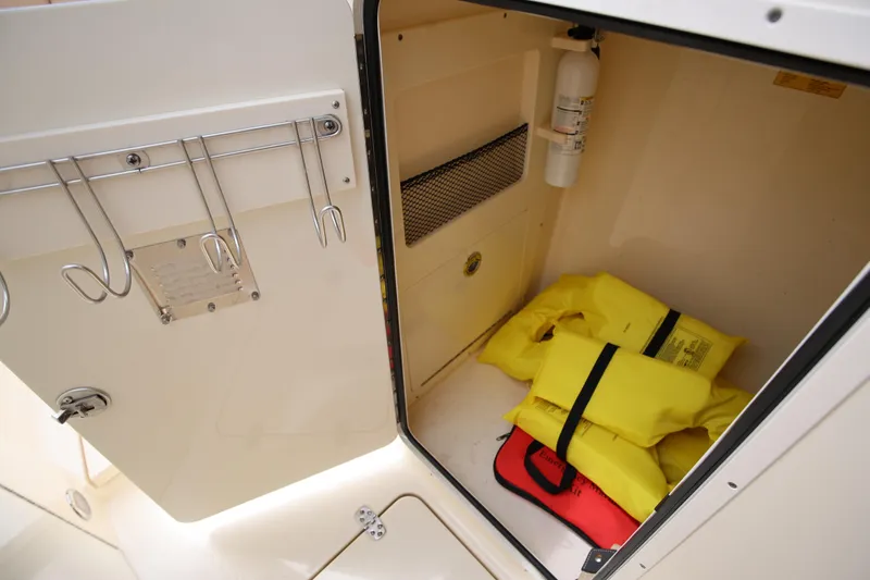  Yacht Photos Pics Storage compartment in 2022 Scout 277 Dorado boat with life jackets and safety equipment.
