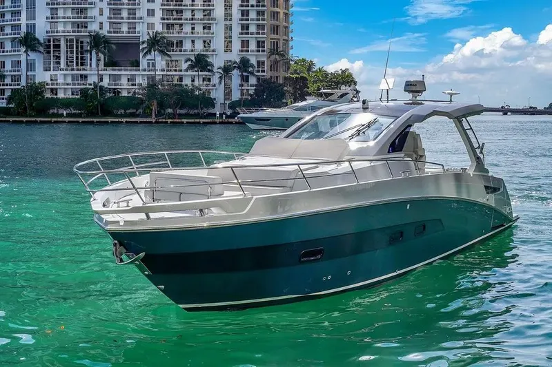  Yacht Photos Pics 2020 Azimut Verve 40 yacht cruising in turquoise waters near luxury waterfront buildings.