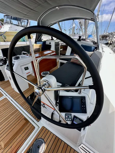Kemosabe Yacht Photos Pics Steering wheel of 2021 Jeanneau Sun Odyssey 440 sailboat with teak deck and navigation equipment.