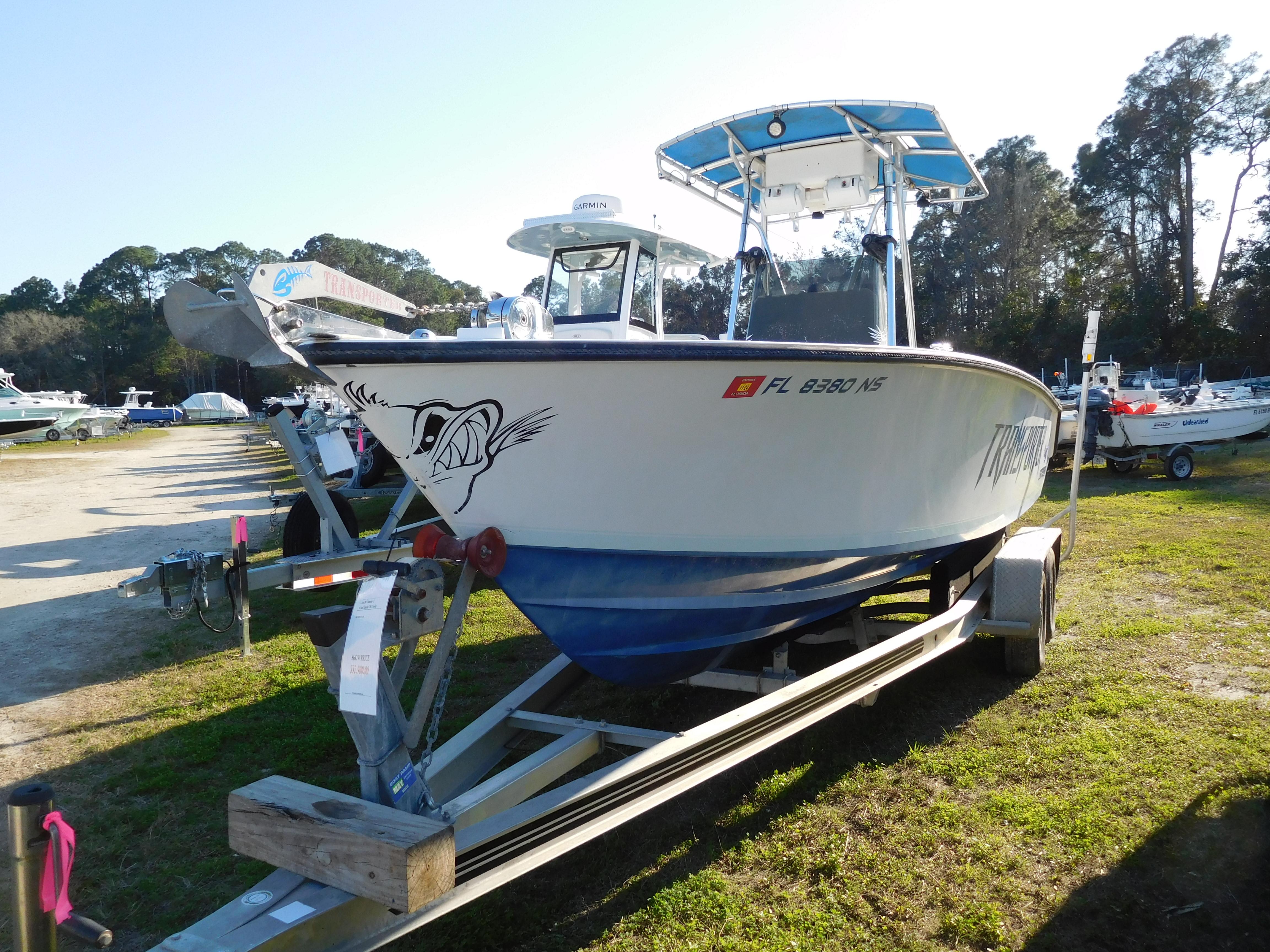 2007 Contender 21 CC boat on trailer, parked outdoors with trees in background.