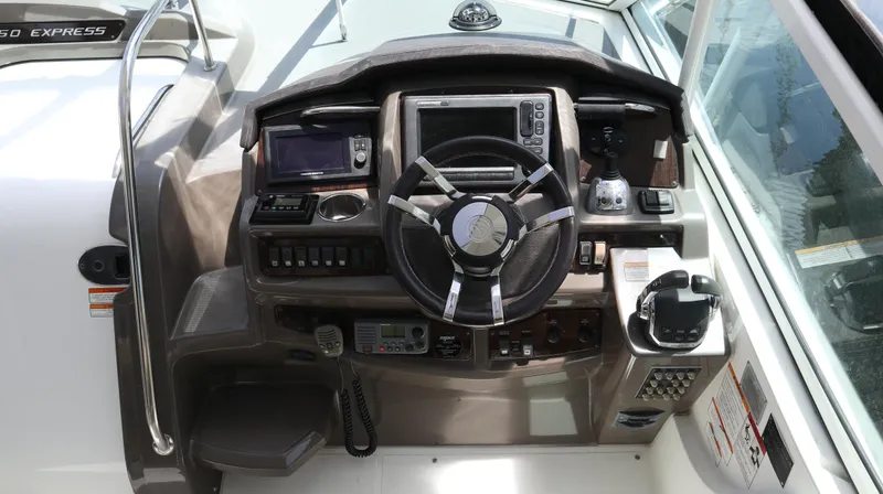 Seas The Day Yacht Photos Pics 2012 Cruisers Yachts 350 Express helm with steering wheel and navigation controls.