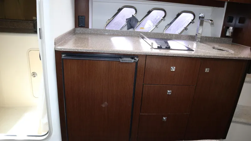 Seas The Day Yacht Photos Pics 2012 Cruisers Yachts 350 Express interior kitchen with wood cabinets and countertop.